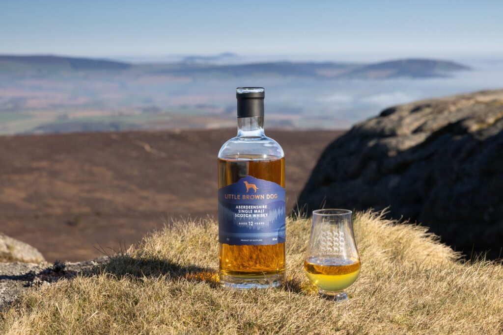 Whisky och glas i höglandslandskap